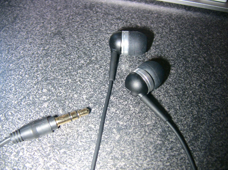 a black earbuds with a microphone connected to it