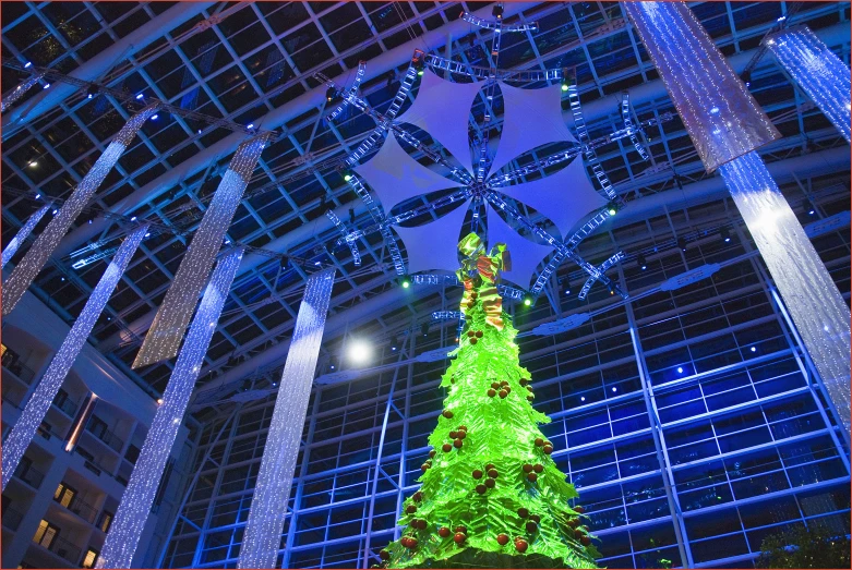 a lit up christmas tree and other decorations in a lobby