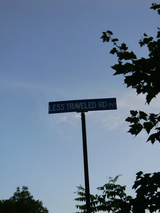 street signs on a pole under a cloudless blue sky