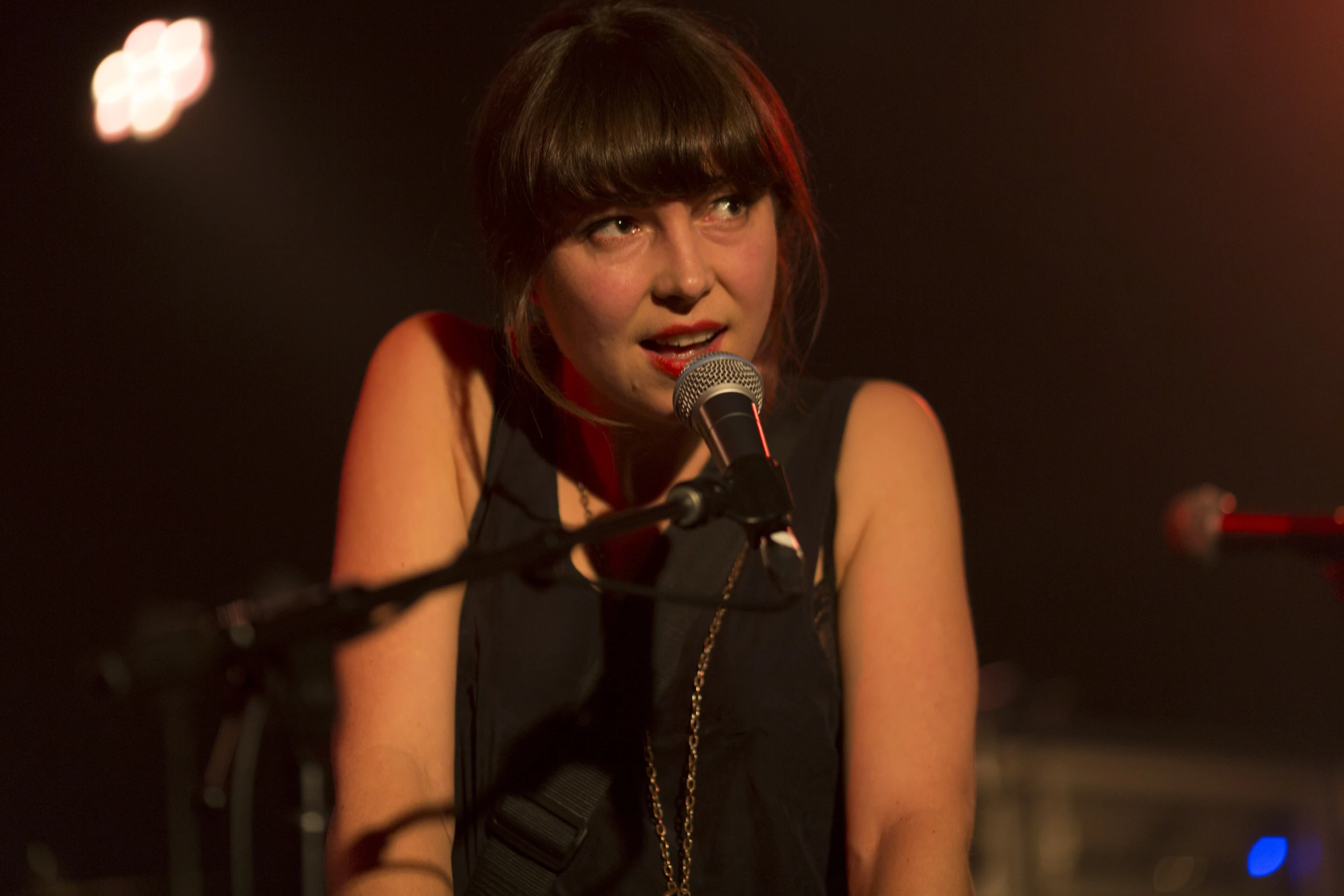 the young woman has a microphone up to her ear