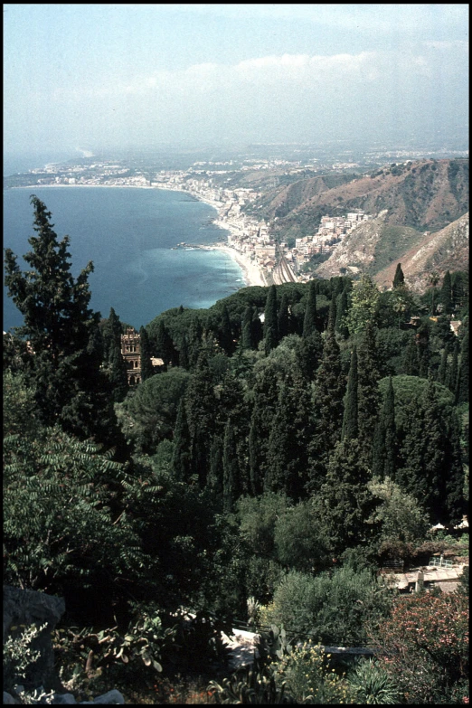 a mountain overlooking a lake and green trees