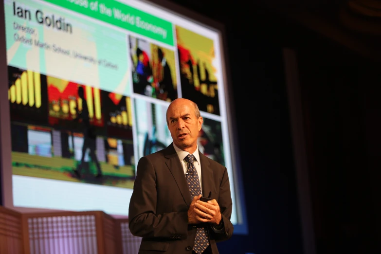 a man in business attire is giving a speech