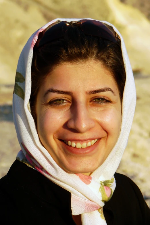 a woman with a scarf around her head smiling