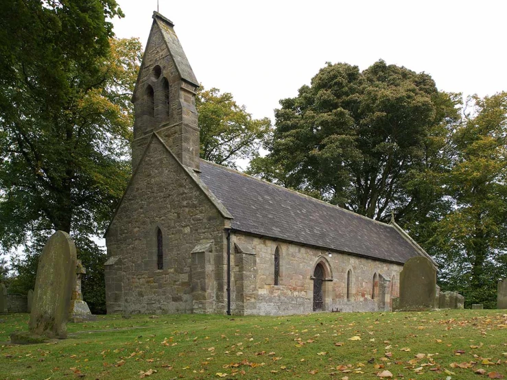 an old church with a steeple and gravestones in front