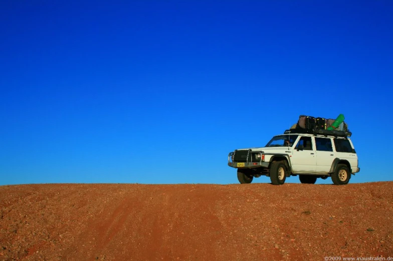 a truck with several things strapped on the back sitting in the desert