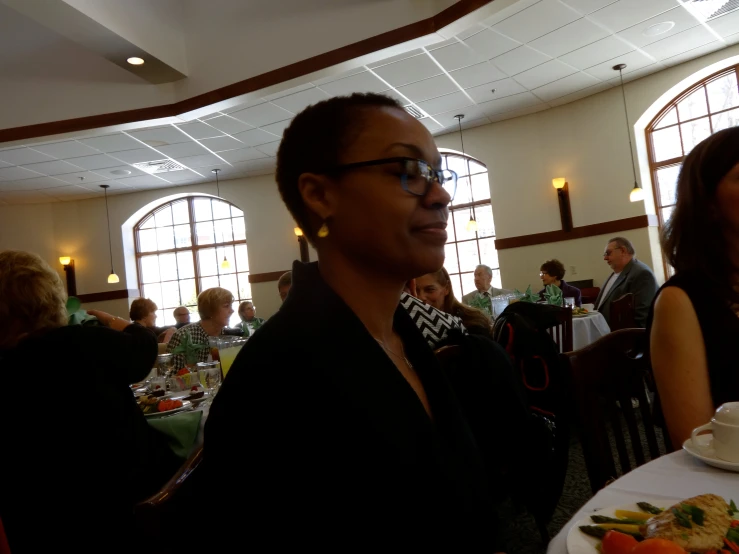 woman in black outfit in front of a table with plates of food