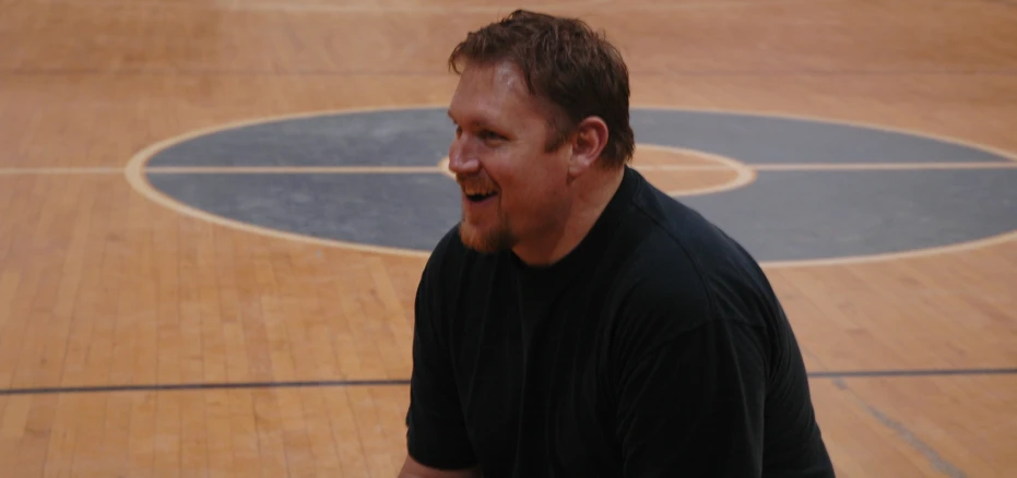 a man with a bald head on a basketball court