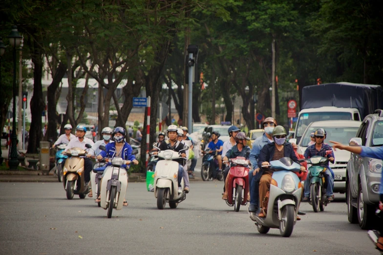a number of people on motorcycles driving down the street