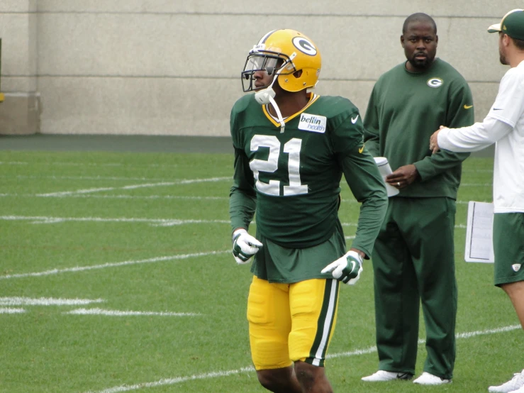 green bay football players wearing green and yellow uniforms on the field