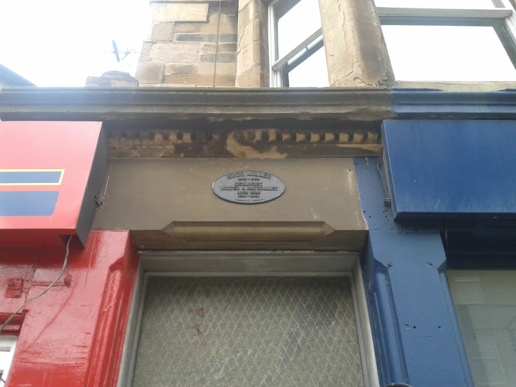the front of an old building with a plaque on it