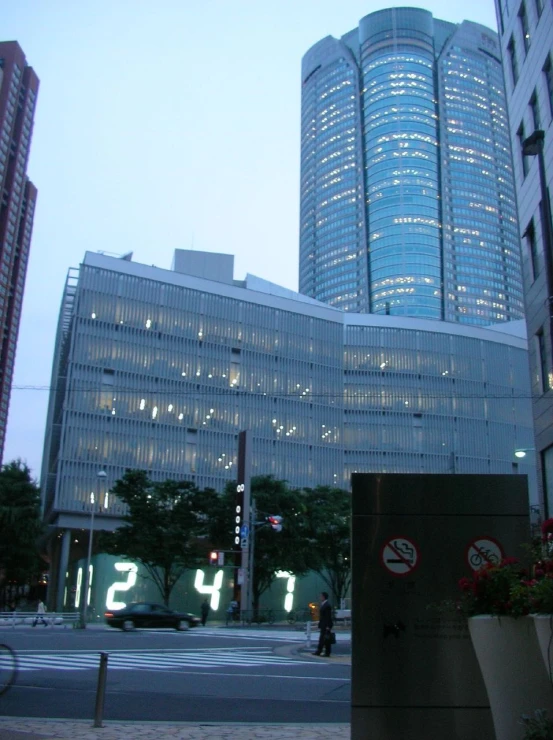 a tall, glassy building sits behind two planters
