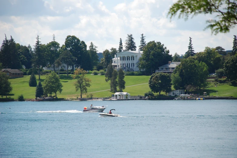 a motor boat on the water with a house and house in the background