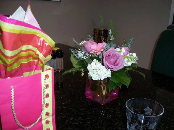 a vase filled with flowers sitting next to a bag