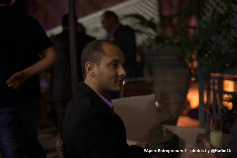 man with nose ring and black jacket at an outdoor cafe