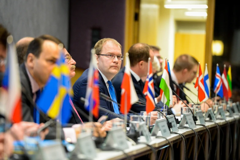 some people in suits and ties are sitting at a table