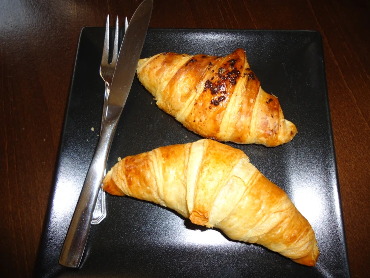 the pastry sticks are on a square black plate