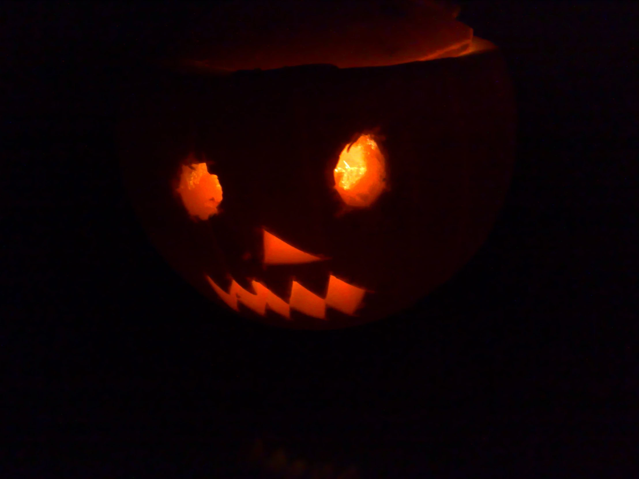 a carved pumpkin lit up in the dark