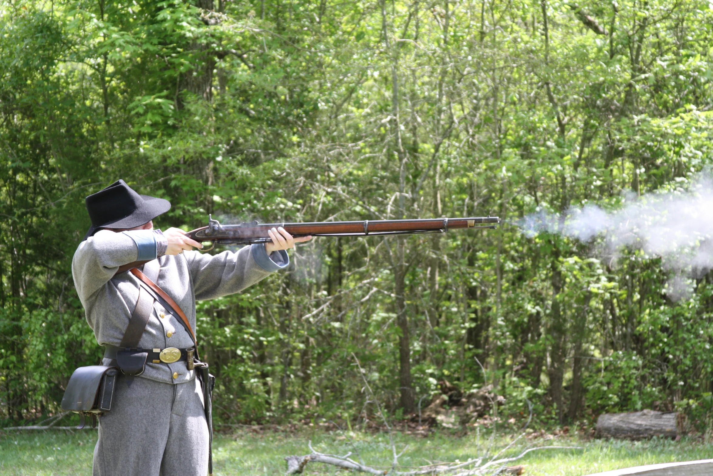 a man is holding a rifle and aiming it with smoke