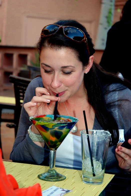 a woman drinking an alcoholic cocktail in the cafe