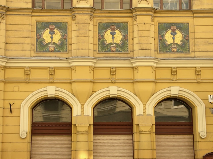 three yellow doors with large windows at a building