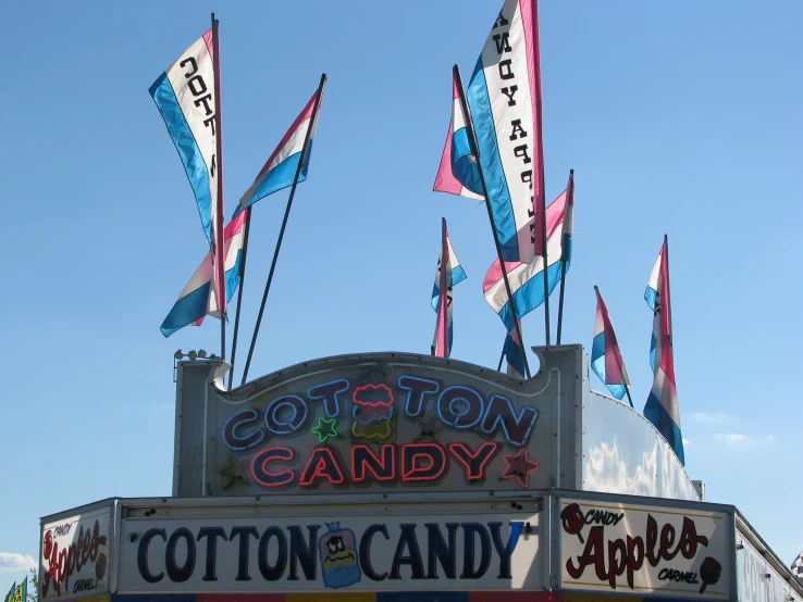 many flags are in the air near a candy store