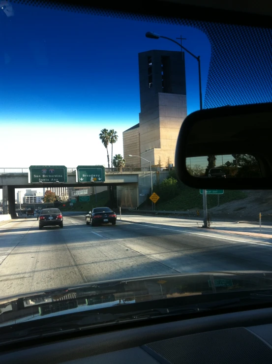 an intersection with many vehicles going under a traffic bridge