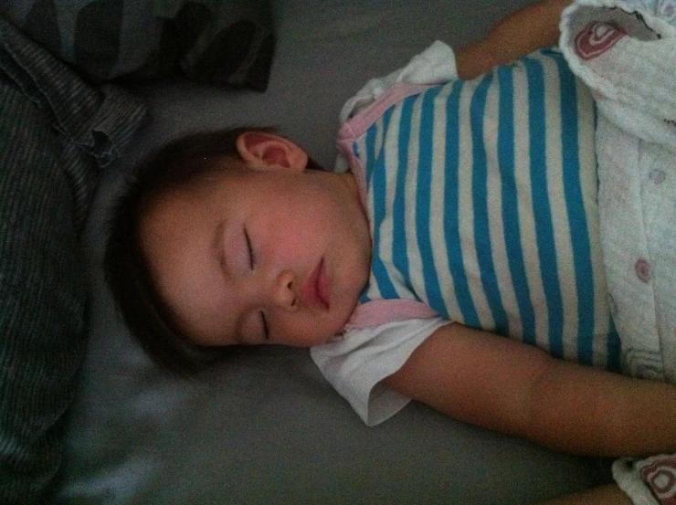 a young child sleeping while laying down