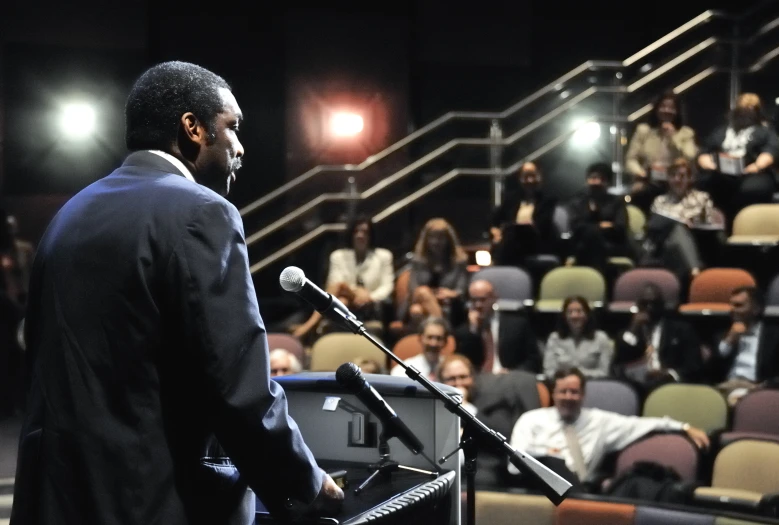 a man standing in front of a microphone and speaking