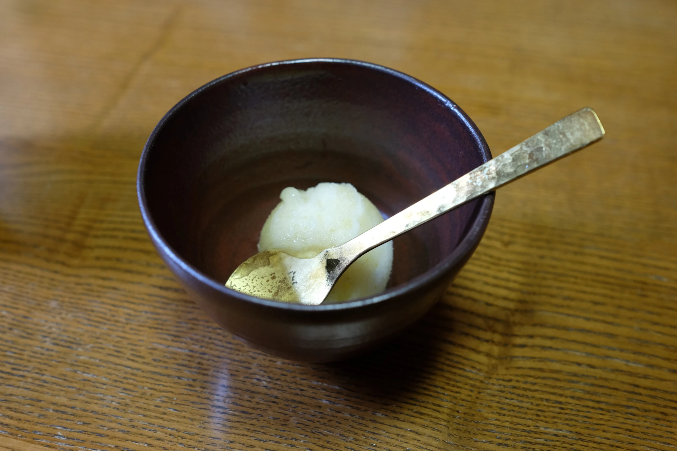 some kind of bowl with two spoons on the table