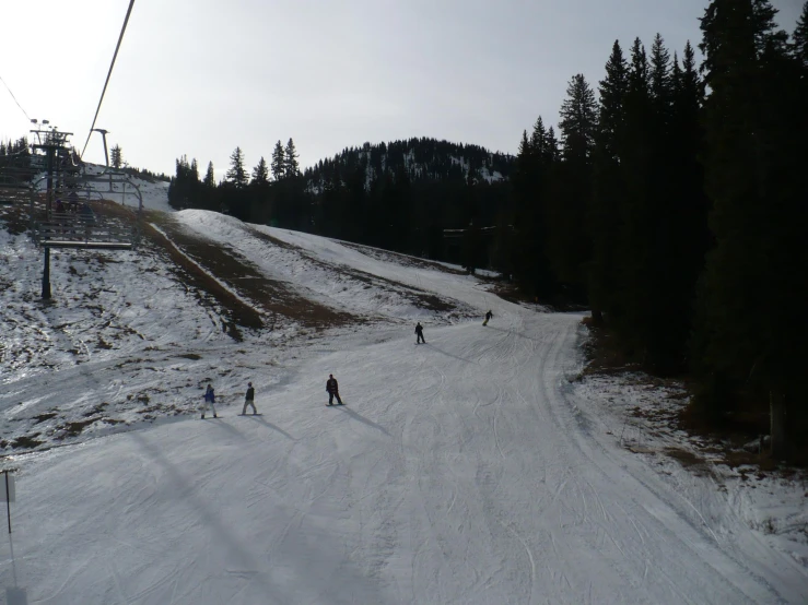 skiers riding down a snowy hill on the ski lift