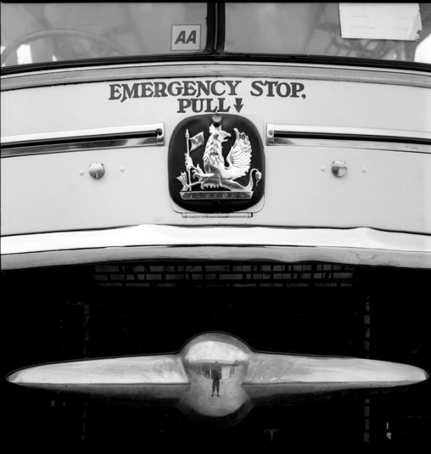 an emblem on the front side of an old white fire truck