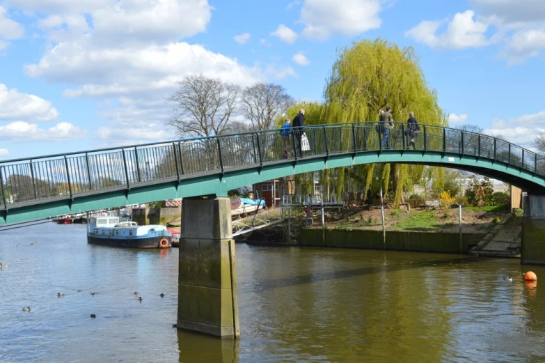 people are standing on the bridge in the water