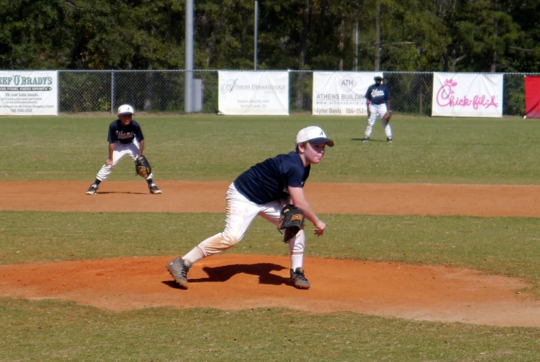 a pitcher on a mound with other men in the background