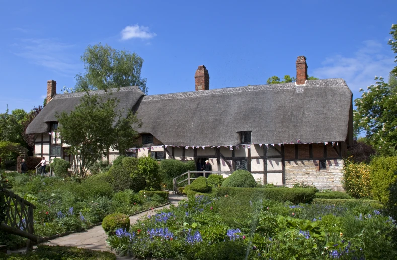 a building with an thatched roof surrounded by lush foliage