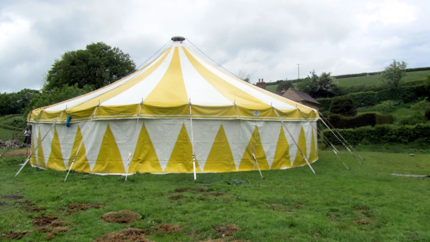 large tent set up in grass in the yard