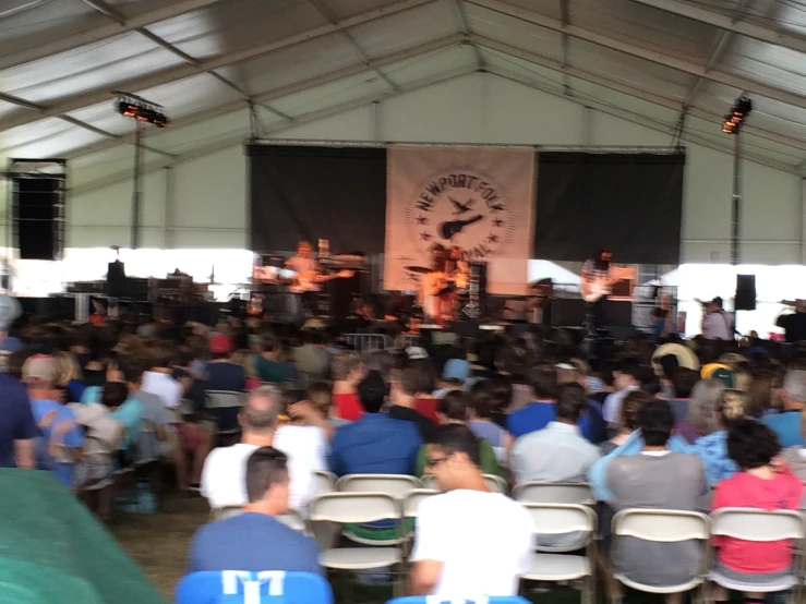 people in chairs watching the musicians perform on stage