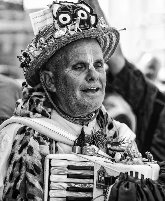 a man with a decorated crown sits in front of people