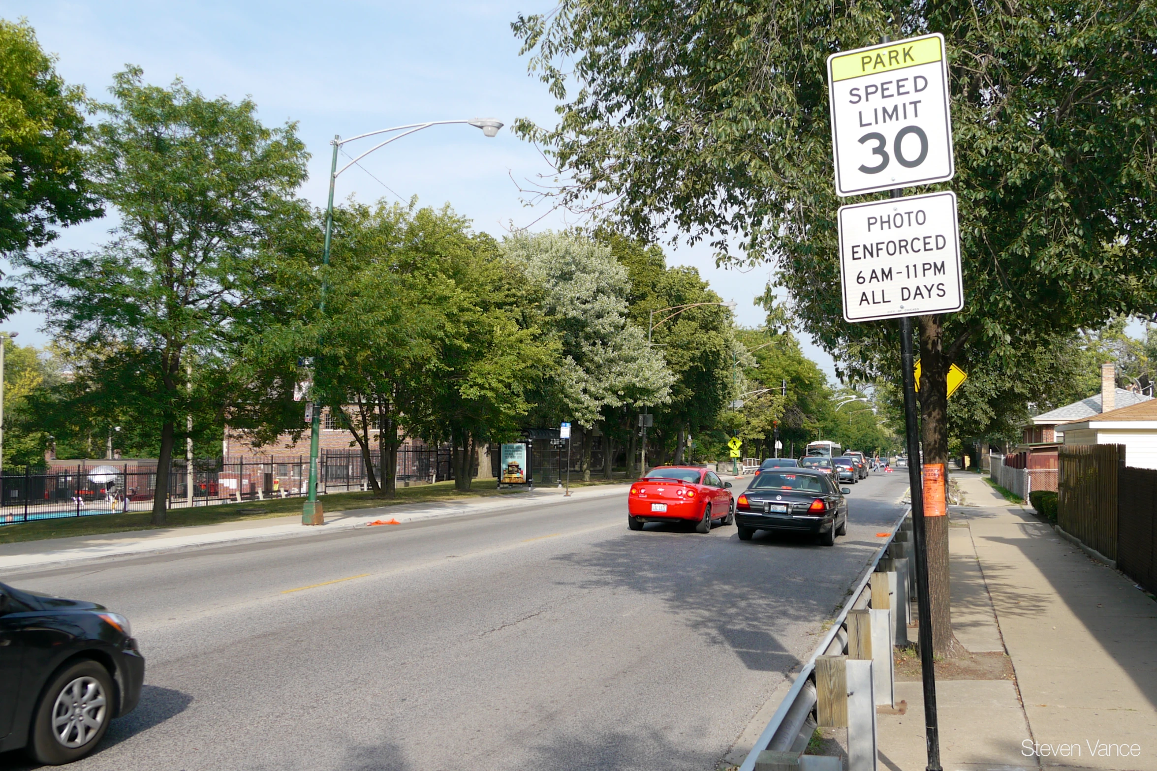 a number sign along the edge of a road near cars