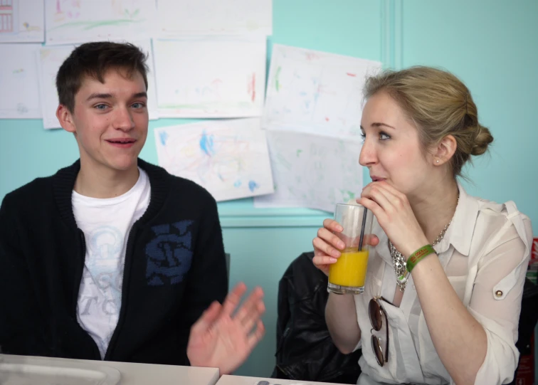 two people sitting at a table with drinks in front of them