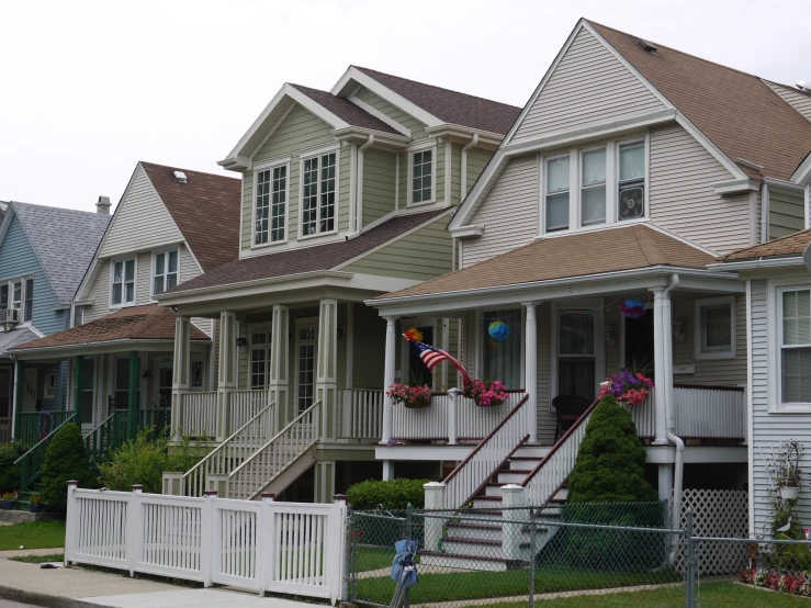 multiple large, row houses with porches and a fence