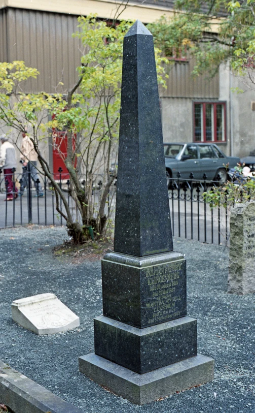 a very tall stone obelisk in the middle of the street