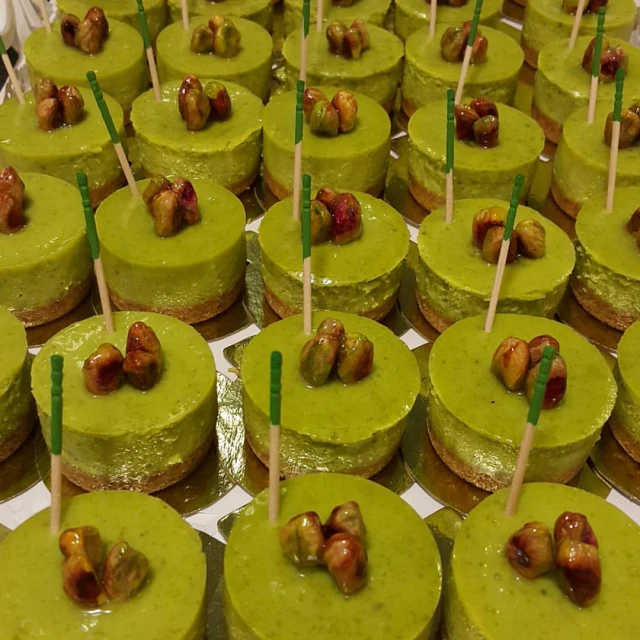 a display of green cakes decorated with wooden dowts