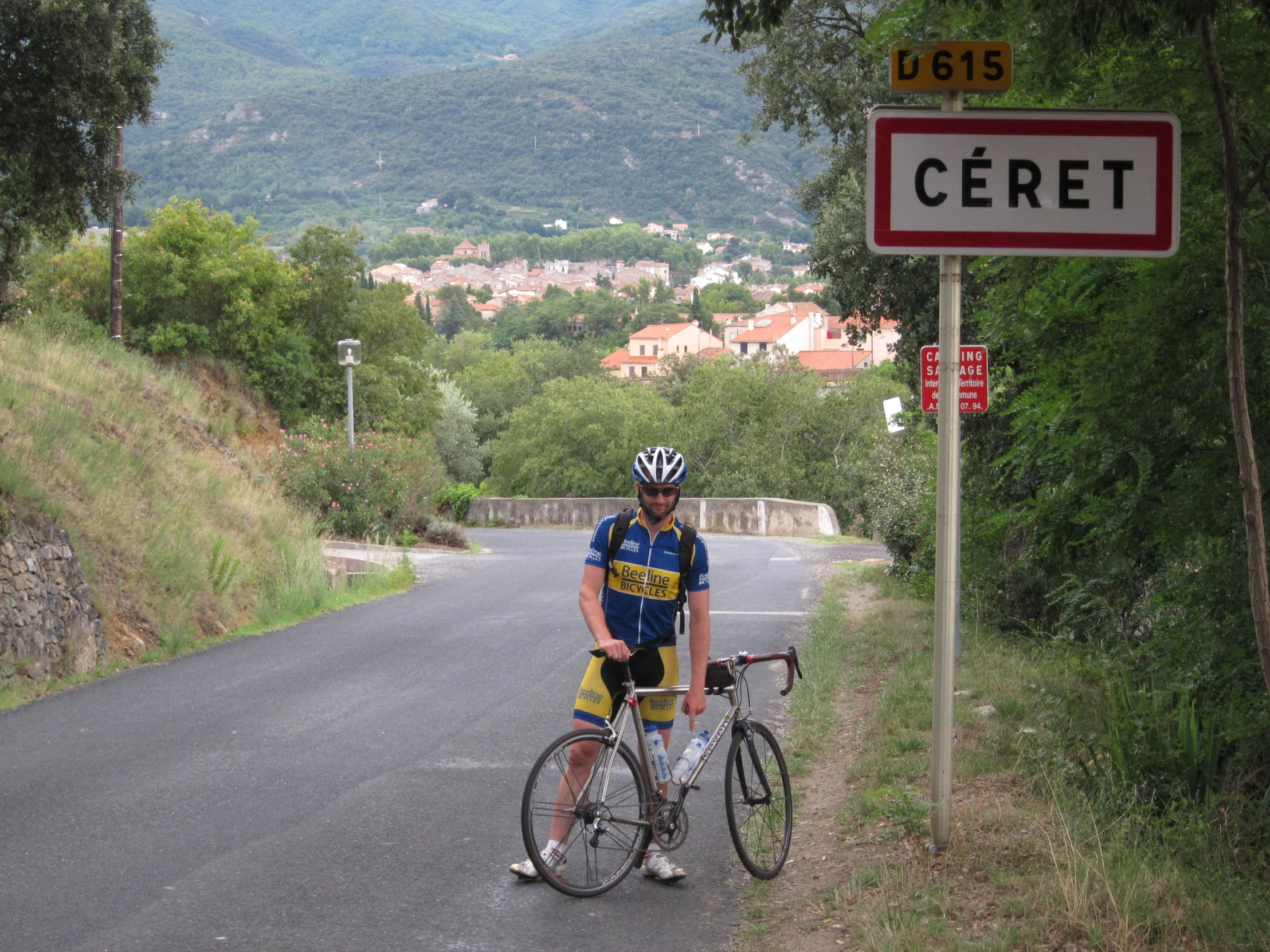 there is a man that is on a bike next to a street sign