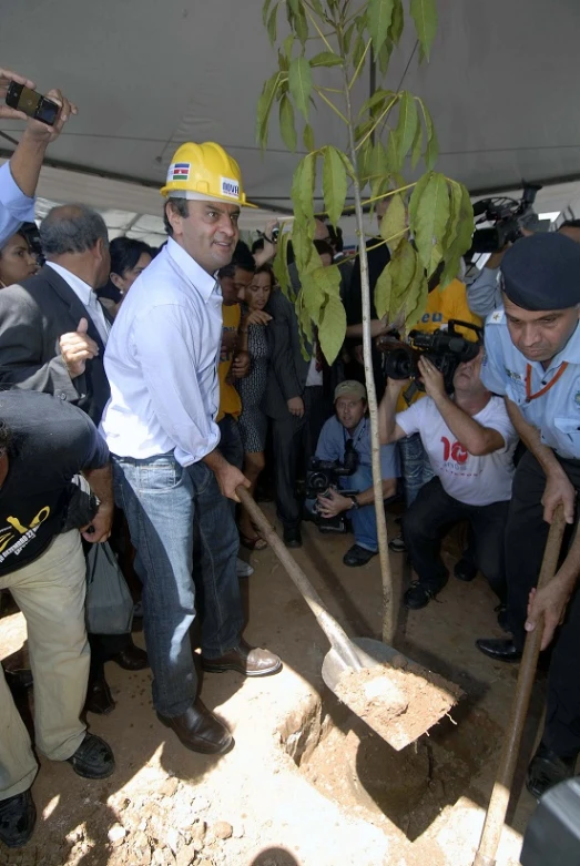 a group of people holding shovels are surrounding a man