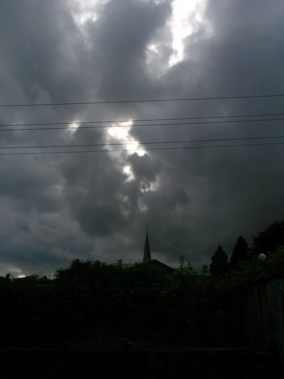 a very cloudy sky has power lines across the street