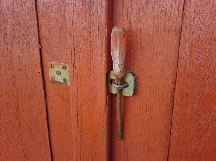 closeup of an old red door with a metal door handle