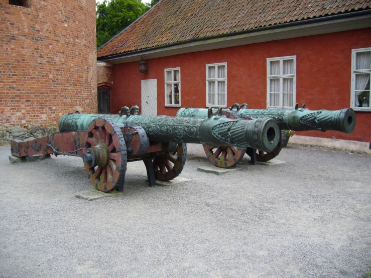 an old cannon is sitting in front of a brick building
