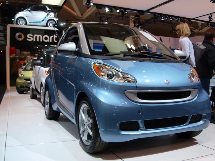 a small car sits on display in front of people