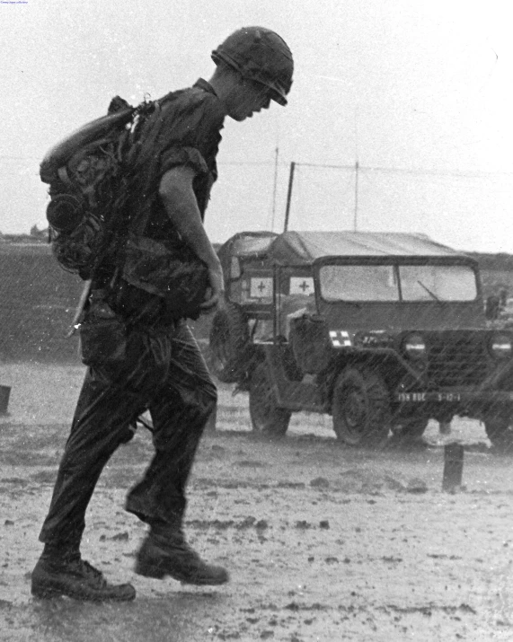 a man is walking across a dirty road