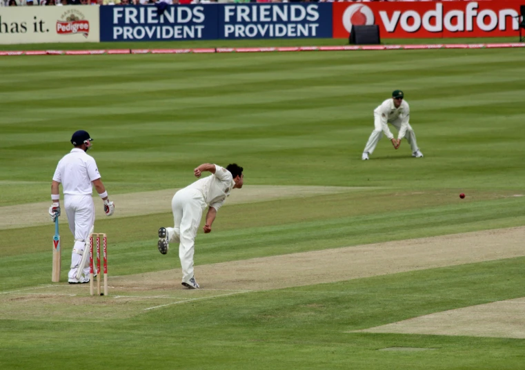 two men in white uniforms playing a game of cricket